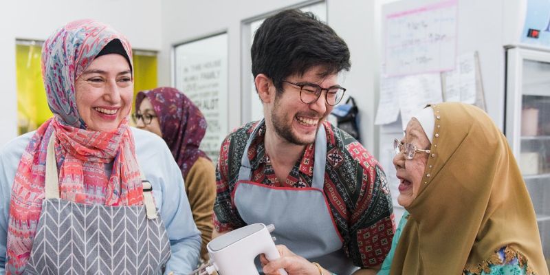 Ilyas and his mother smiling and laughing in a kitchen