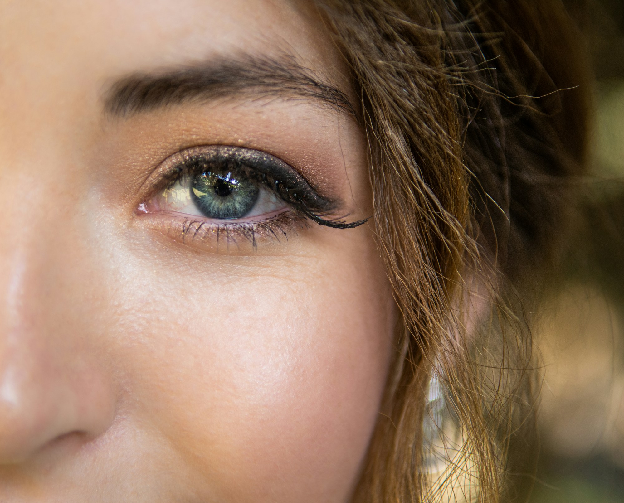 Close-up of a woman’s clear, glowing skin in natural light.
