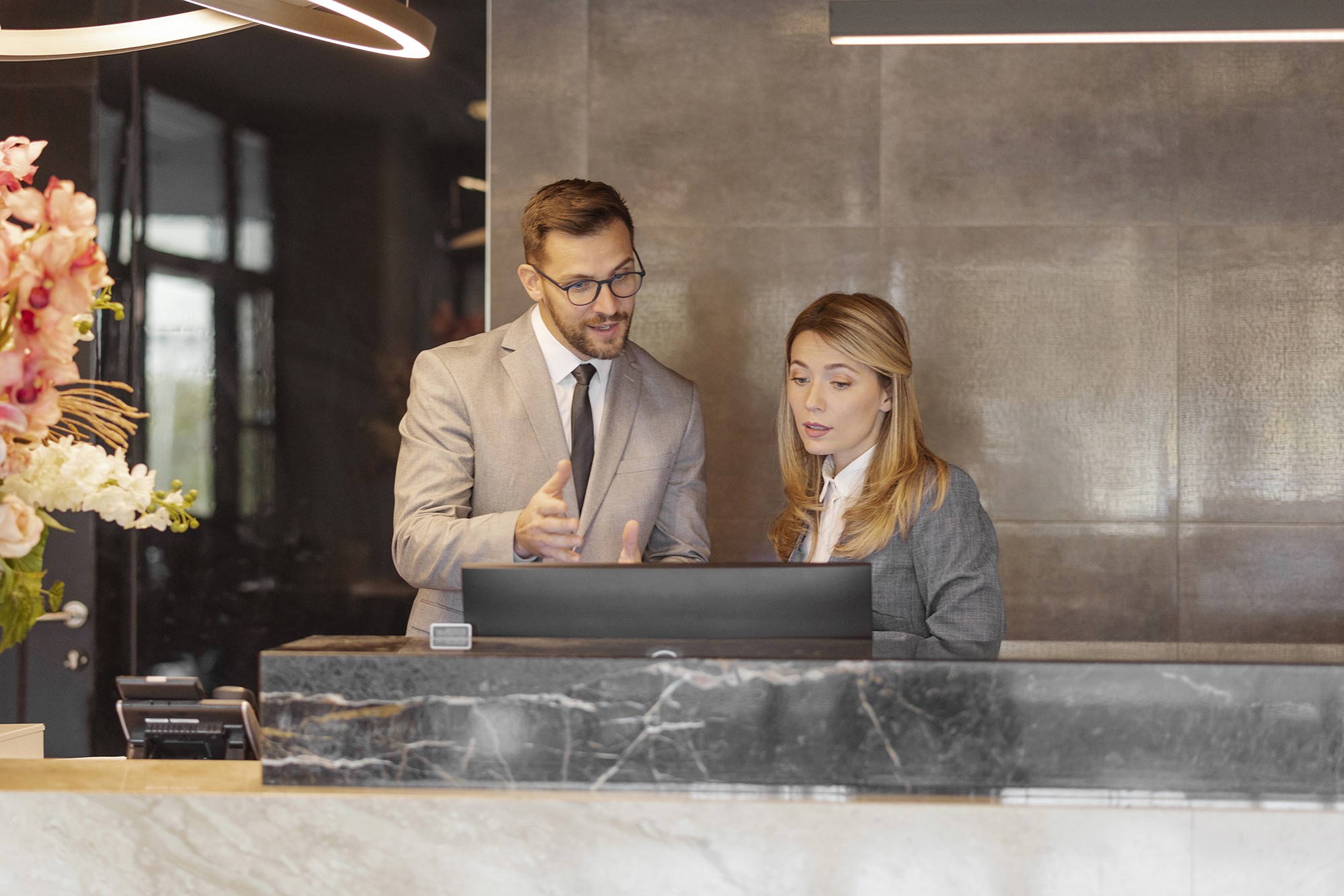 Two people looking at the same monitor