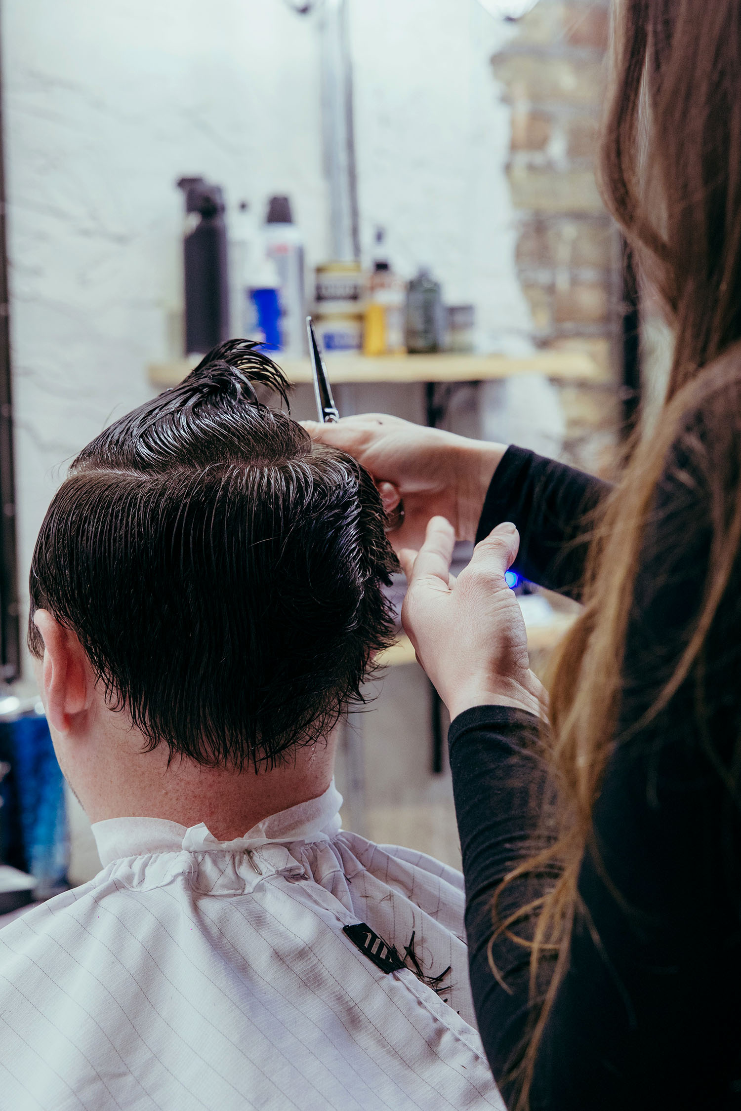 Close-up photo of a barber performing a precise scissor cut at Old Town Barber in Chicago, capturing attention to detail and professional craftsmanship.