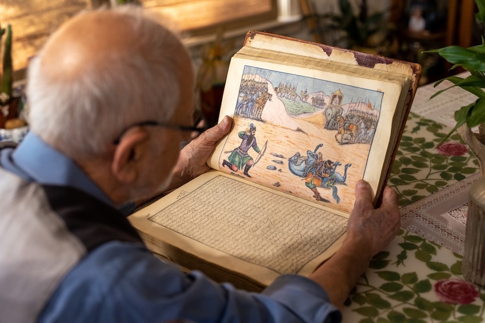 Bubjan with book and speaking to camera