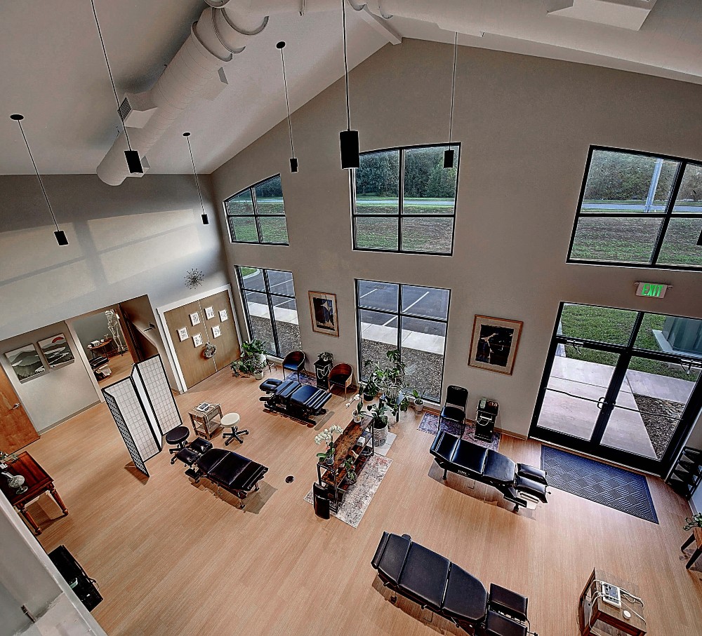 Spacious living area with high ceilings, large windows, and multiple seating arrangements. Bright and inviting atmosphere.