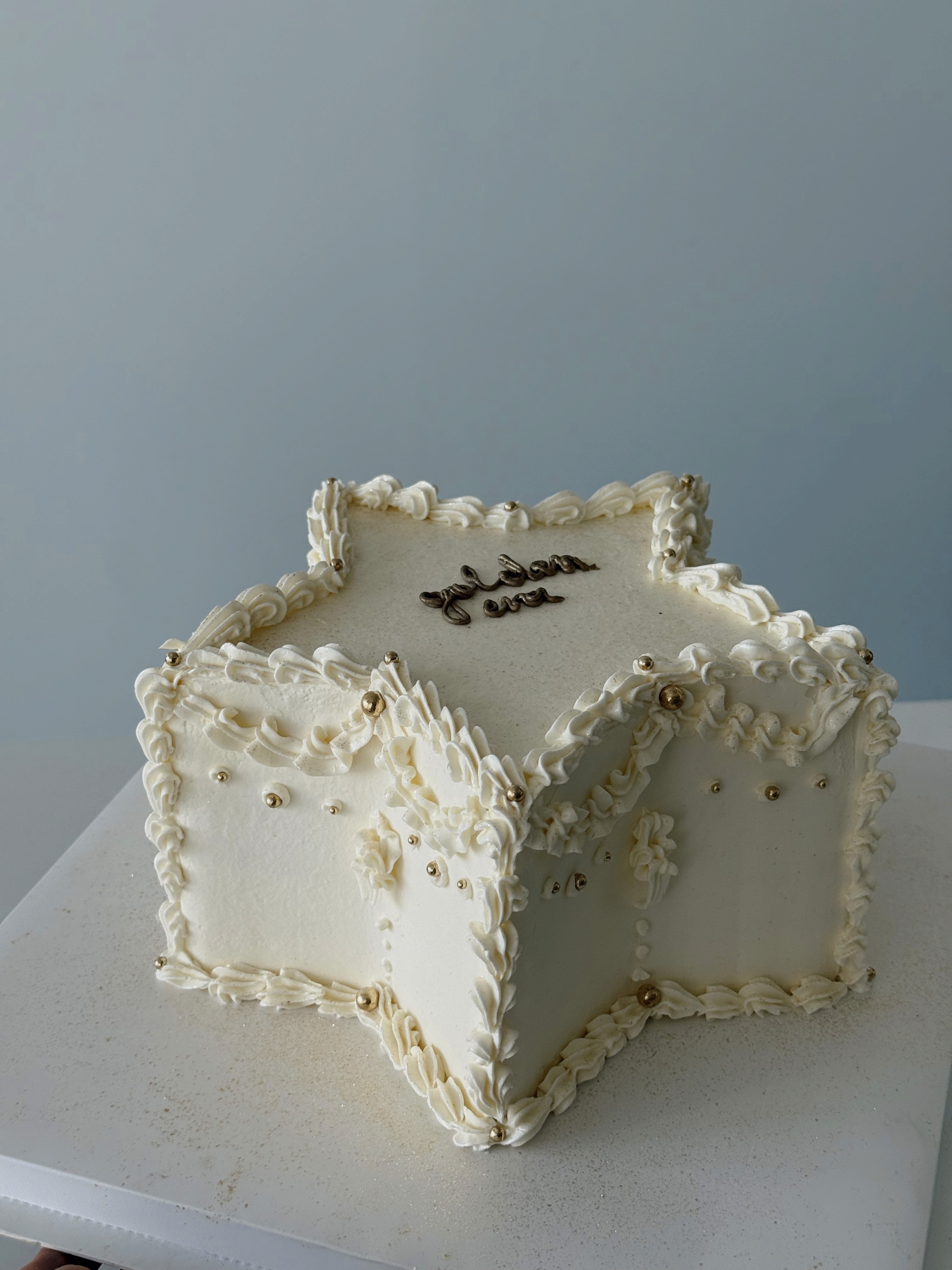 Star-shaped white cake with vintage ruffle piping and pearl details