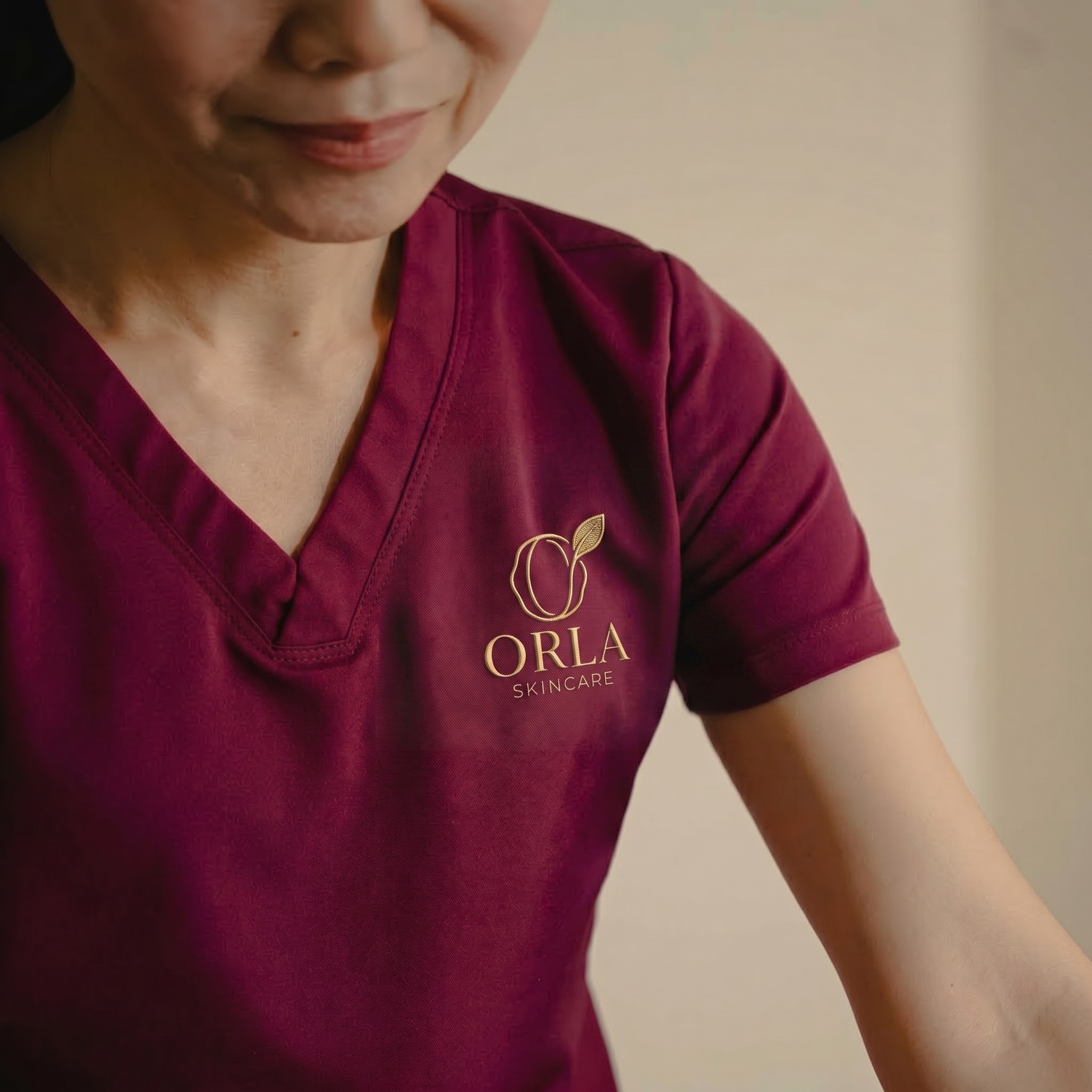 spa worker wearing a work cloth embroided with orla skincare
