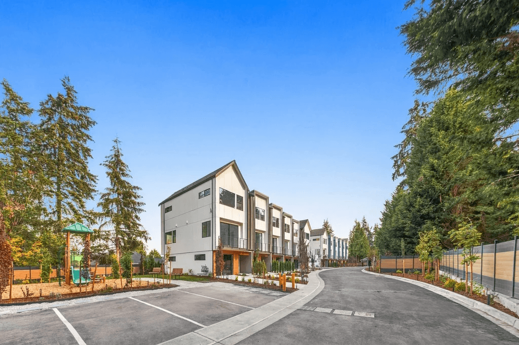 Duchess Townhomes community in Bothell with a children's play area, landscaping and tall evergreens