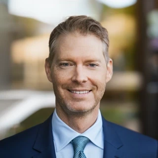 Porträt eines lächelnden Geschäftsmanns im Anzug vor modernem Bürogebäude