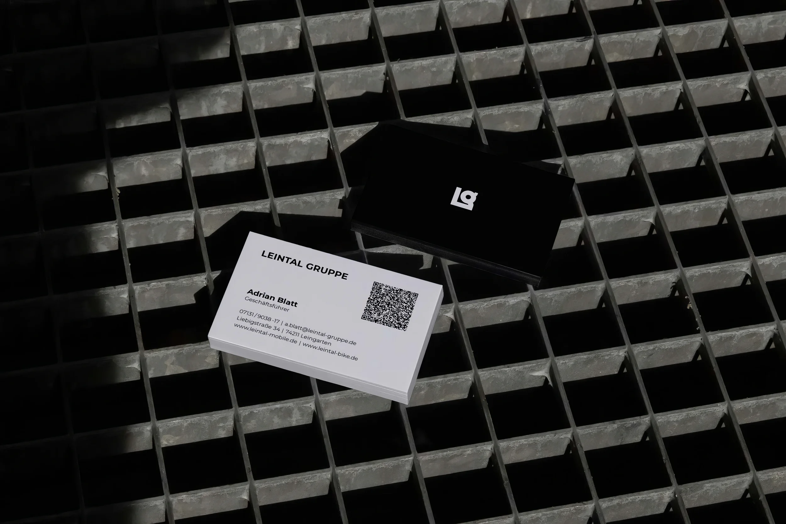 Junger Mann mit gebrandetem weißen Pulli mit LG-Logo, modernem Notizbuch mit Slogan der Leintal Gruppe und Jutebeutel mit geometrischem Logo-Muster.