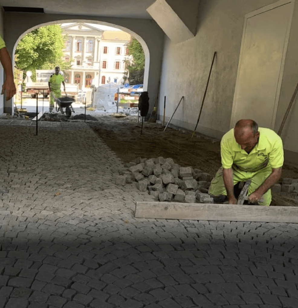 Strub Bau AG crew installing underground drainage pipes on a construction site with excavators – showcasing civil and utility engineering in Switzerland.