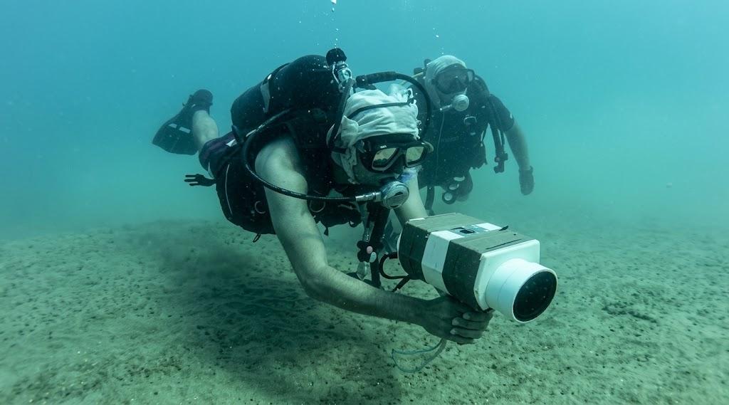 Historical profile image of a diver using an underwater camera.
