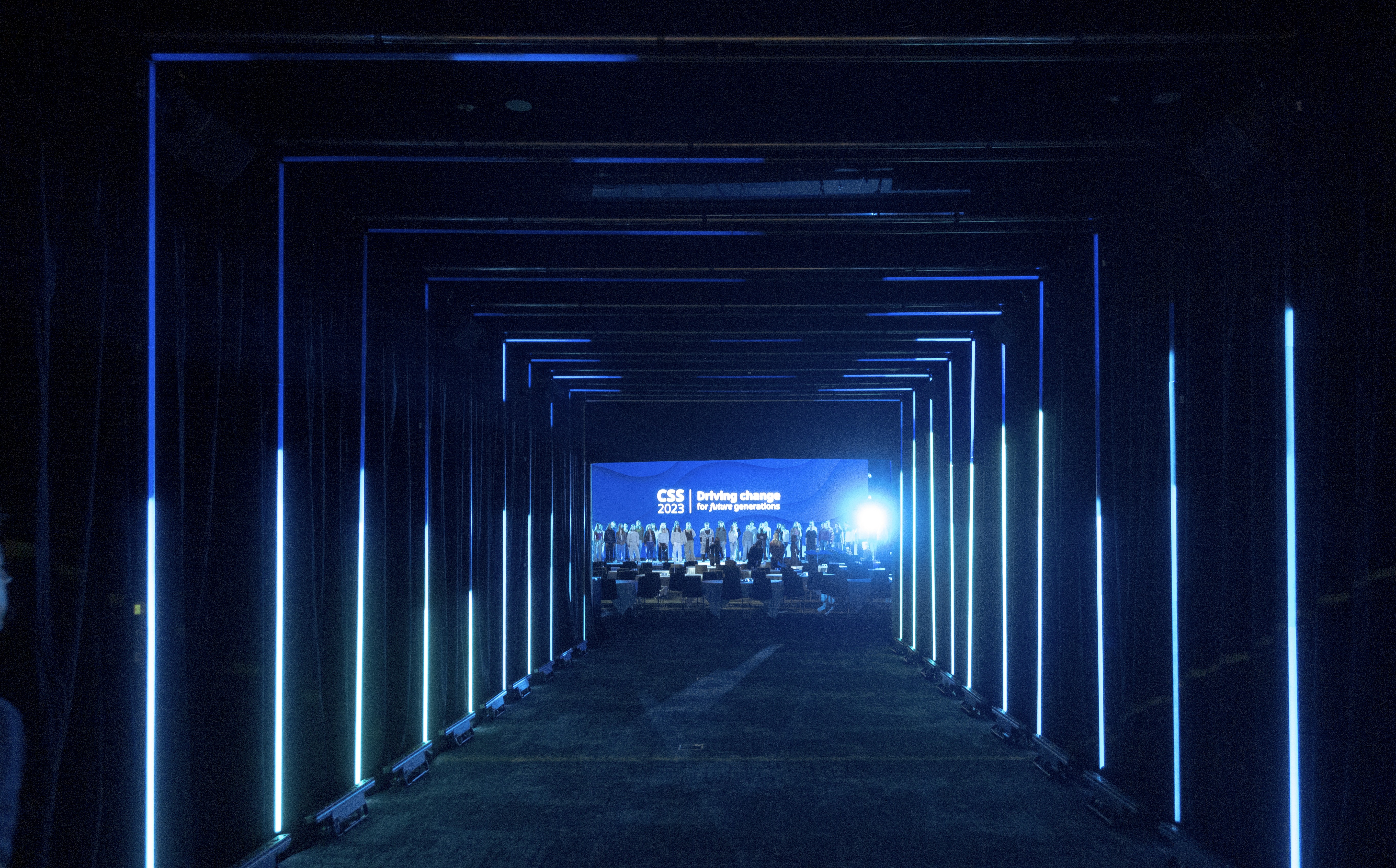 En blå tunnel med ljus som leder till ett konferensrum