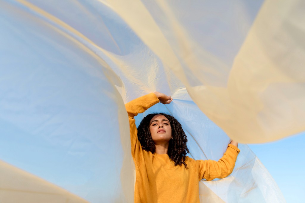 Joyful woman under flowing fabric, symbolising freedom and growth with HeadHealth therapy services