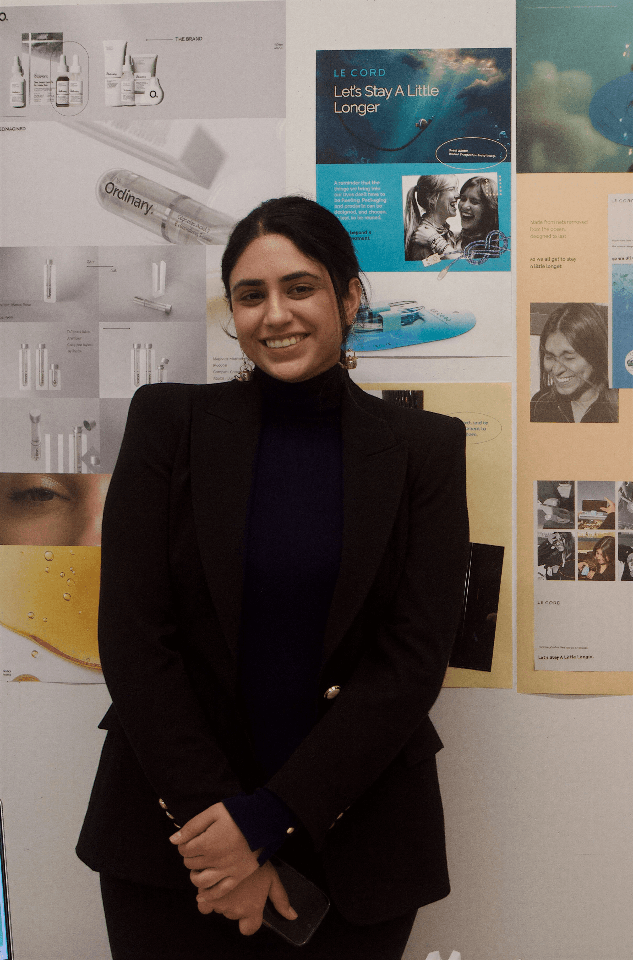 A model dressed in a mustard yellow blazer and cream trousers poses confidently against a minimalist background with sky blue and beige tones, exuding a modern and chic fashion aesthetic.