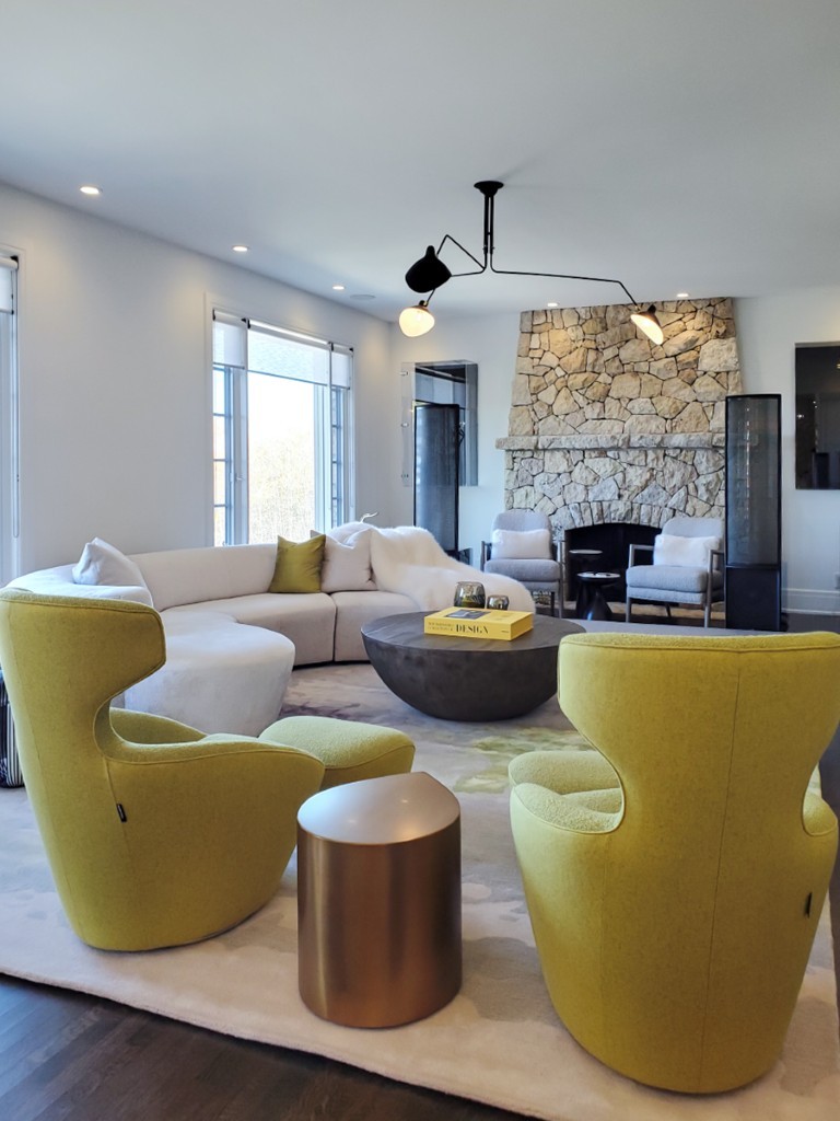 Image of Luxury living room design with green chairs, white sofa, stone fireplace by KHD Homes design-build experts.