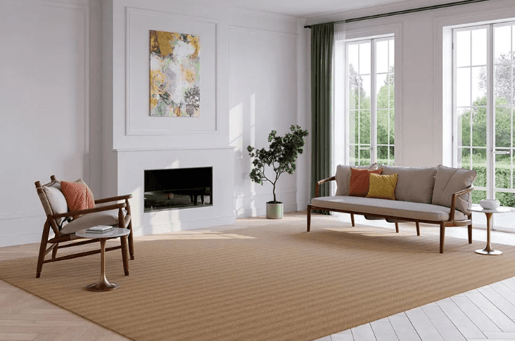 Cozy living room with beige tones; large window offers ocean view. Rustic wooden table and pampas grass create a serene, relaxing atmosphere.