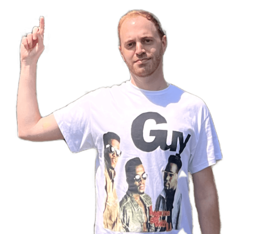 image of me pointing up to previous statement. I am white with reddish hair and I am wearing a t-shirt with 80's boy band "Guy" on it