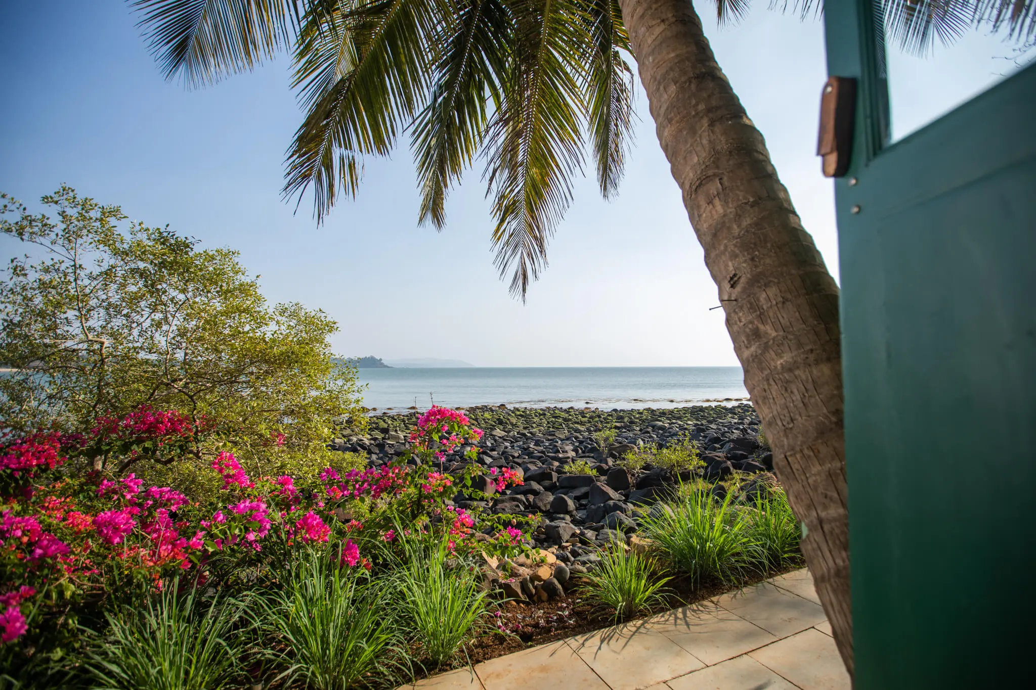 Sea View Hut 7 at Casa Jaali — palms over the rocky shore