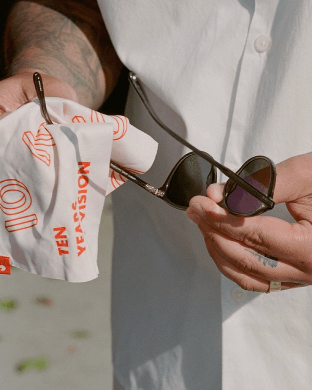 Garrett Leight California Optical anniversary campaign materials showing the 10-year mark applied to white branded lens cloth
