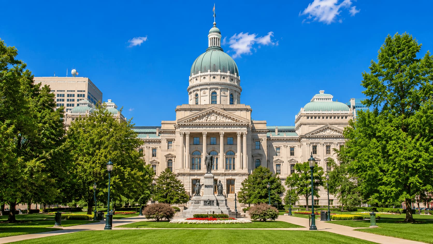 Indiana State Capitol in Indianapolis with green park and clear sky