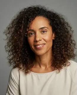a brown woman with curly long hair wearing white dress