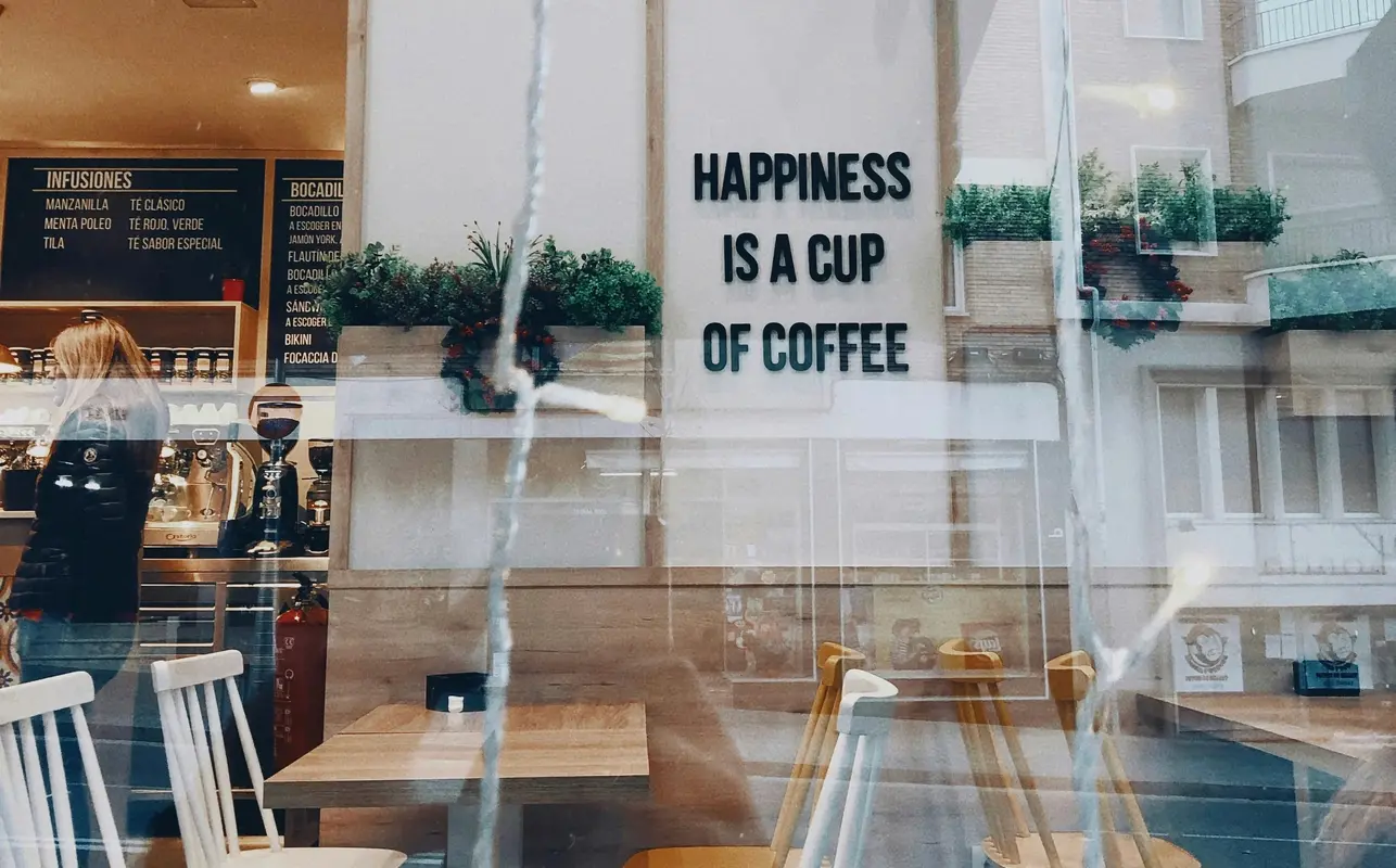 Image of a cozy coffee shop in Barcelona with rustic decor and a perfectly crafted latte served in a ceramic cup.