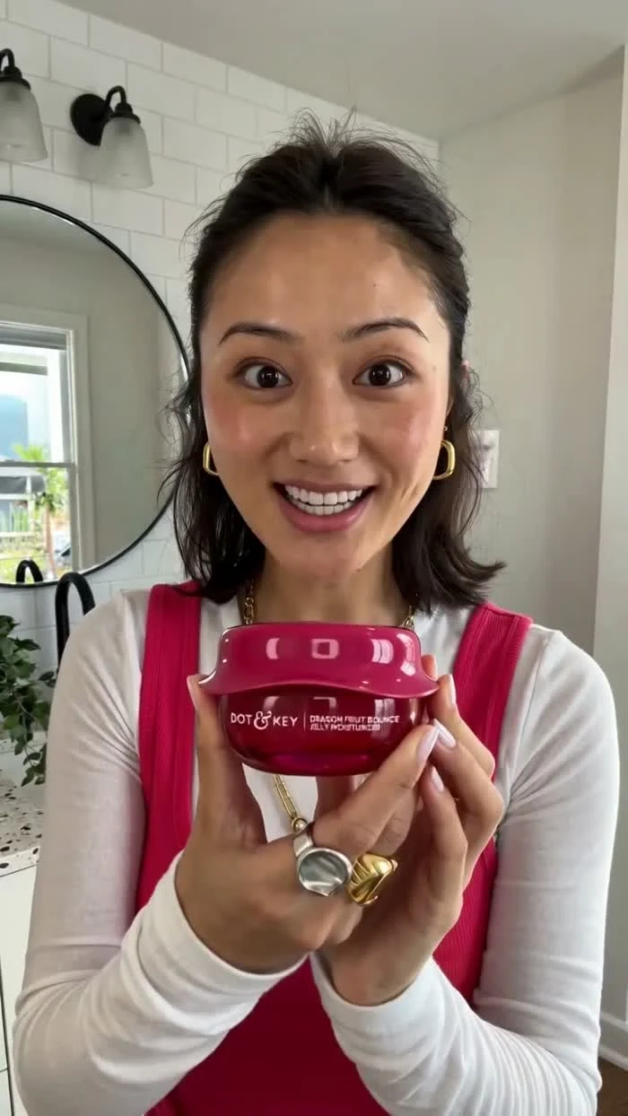 A direct-to-camera product demonstration keeps the creator and skincare packaging in focus.