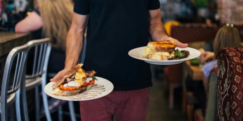 A Malaysian F&B staff serving food to customers