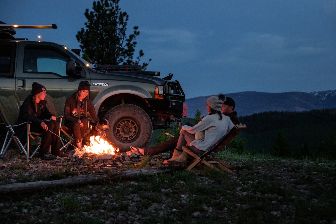 Travellers setting up camp beside their 4x4 vehicles at dusk in Namibia