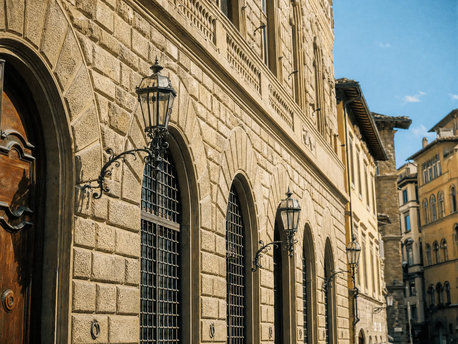 Renaissance stone palazzo with iron lanterns on a Florence street