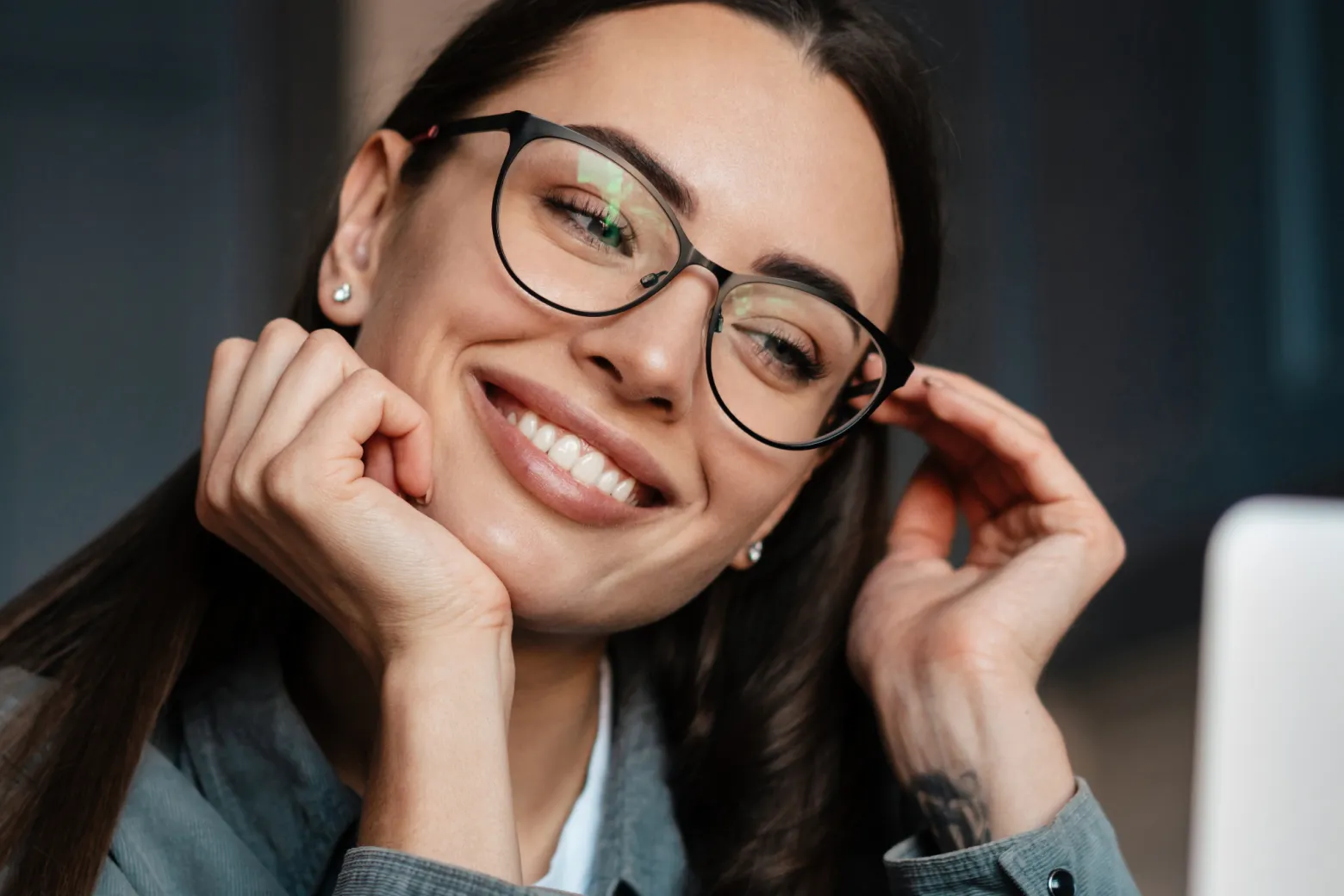 Kobieta z uśmiechem prezentująca efekty bondingu na swoich zębach.