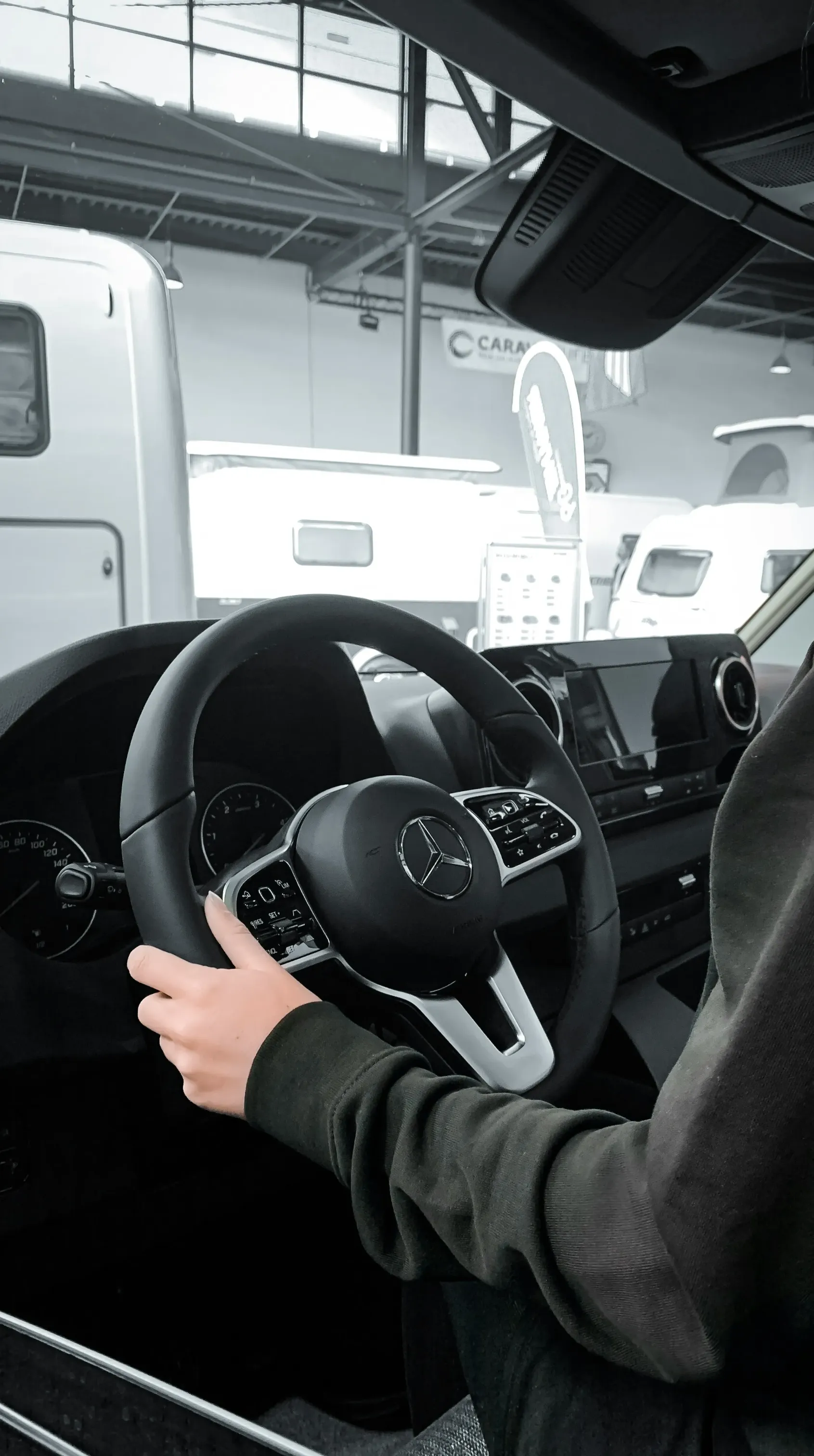 a person sitting in a car with a steering wheel
