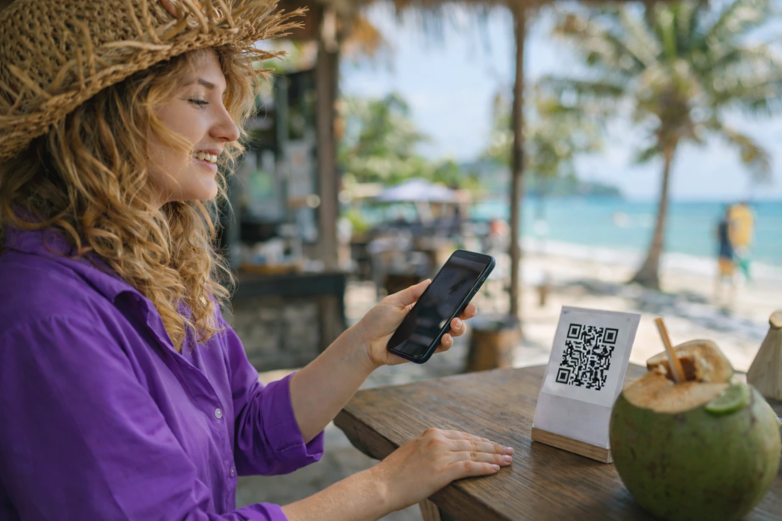 Mujer escaneando un código en un parador de playa para realizar pagos a través de QR de manera rápida y sin contacto