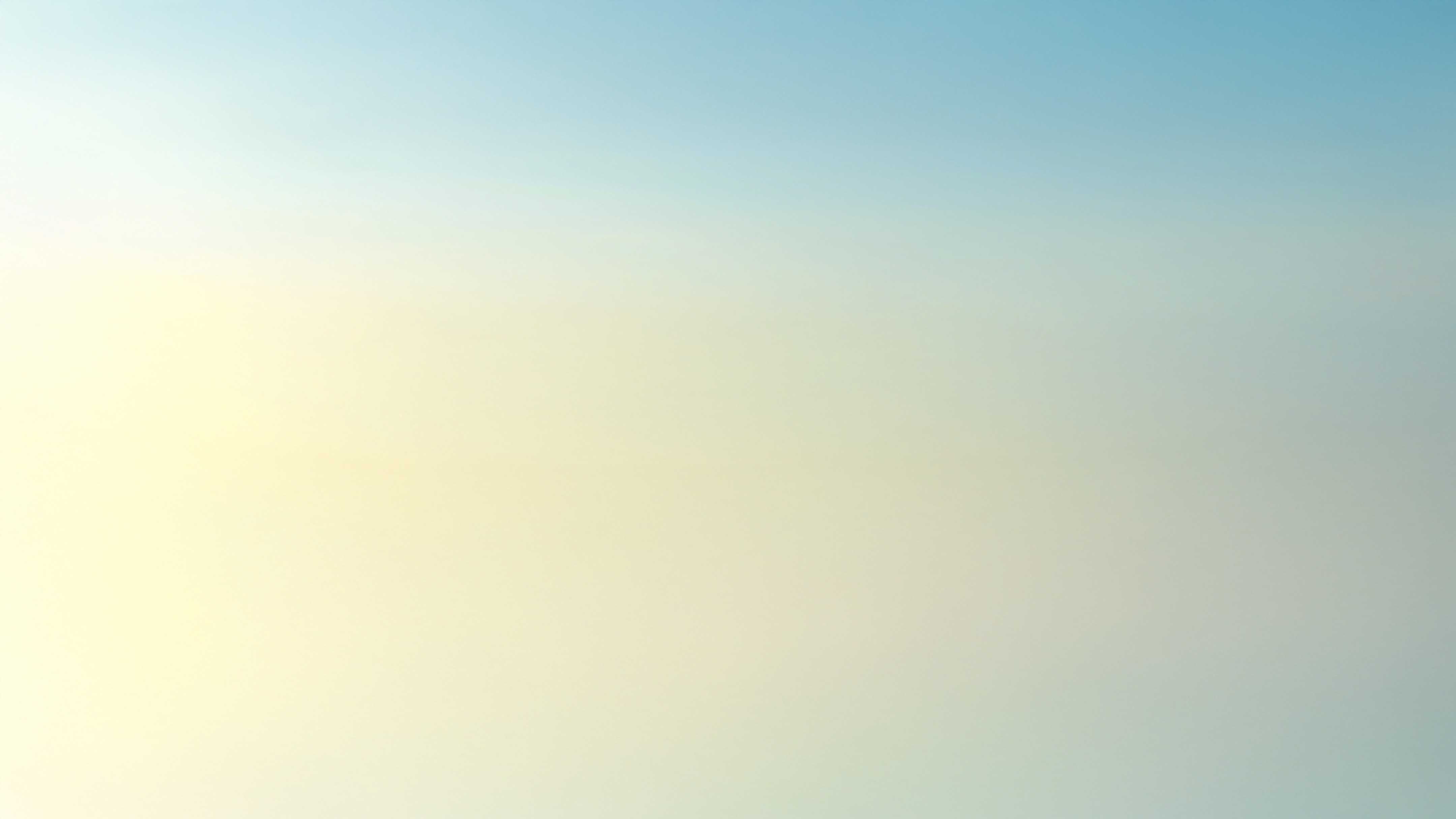 Soft gradient sky, transitioning from pale yellow to light blue, creating a serene & calming atmosphere.