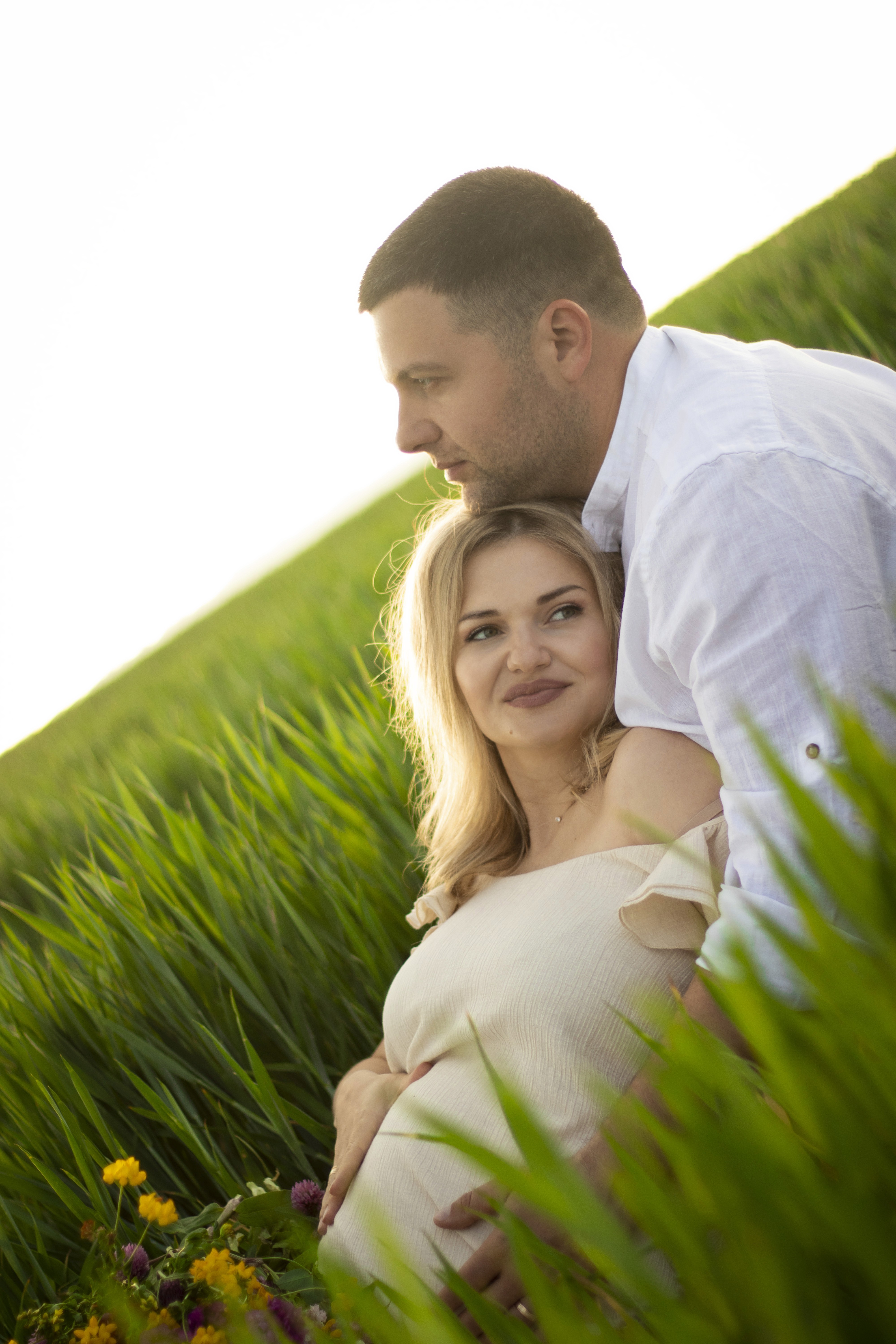 woman holding baby beside man smiling