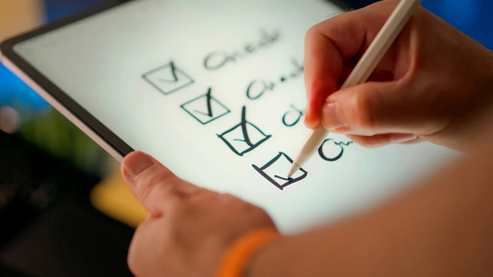 Hands using a stylus to check boxes on a checklist shown on a tablet screen