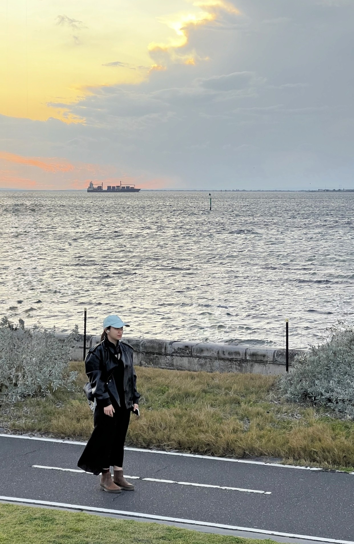 A thoughtful young person with dark hair gazes to the side, captured in soft black and white lighting.