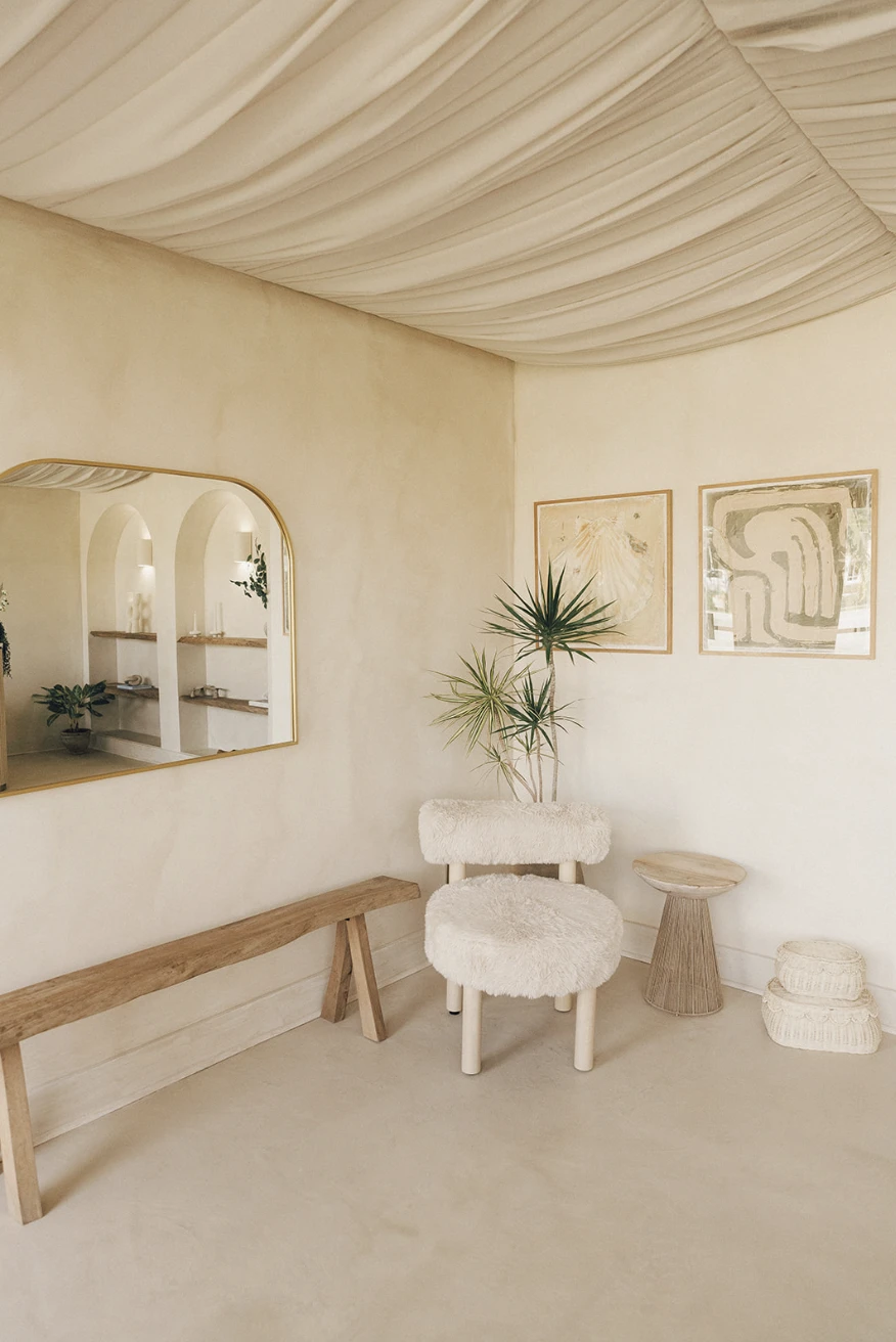 Neutral upholstered seating and natural wood furniture inside Manipura wellness studio