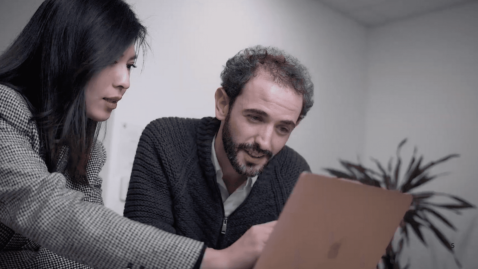 a couple of women sitting at a table with a laptop