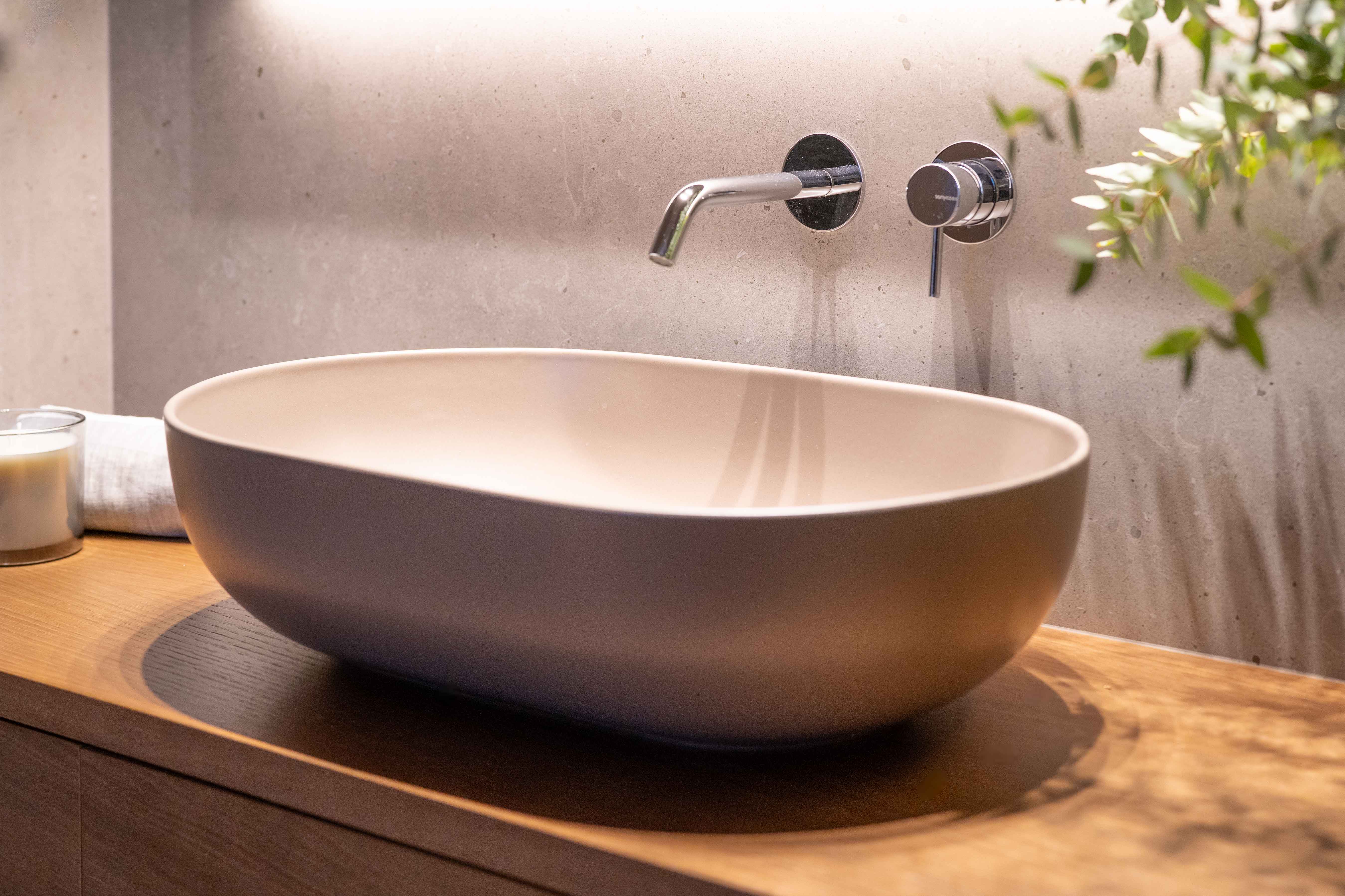 Baño con mueble de madera y pila sobre encimera