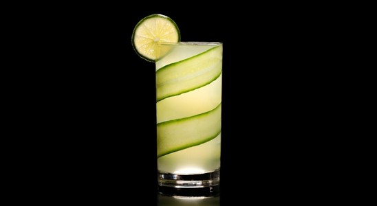 A closeup of a Cucumber Gimlet drink against a dark background.