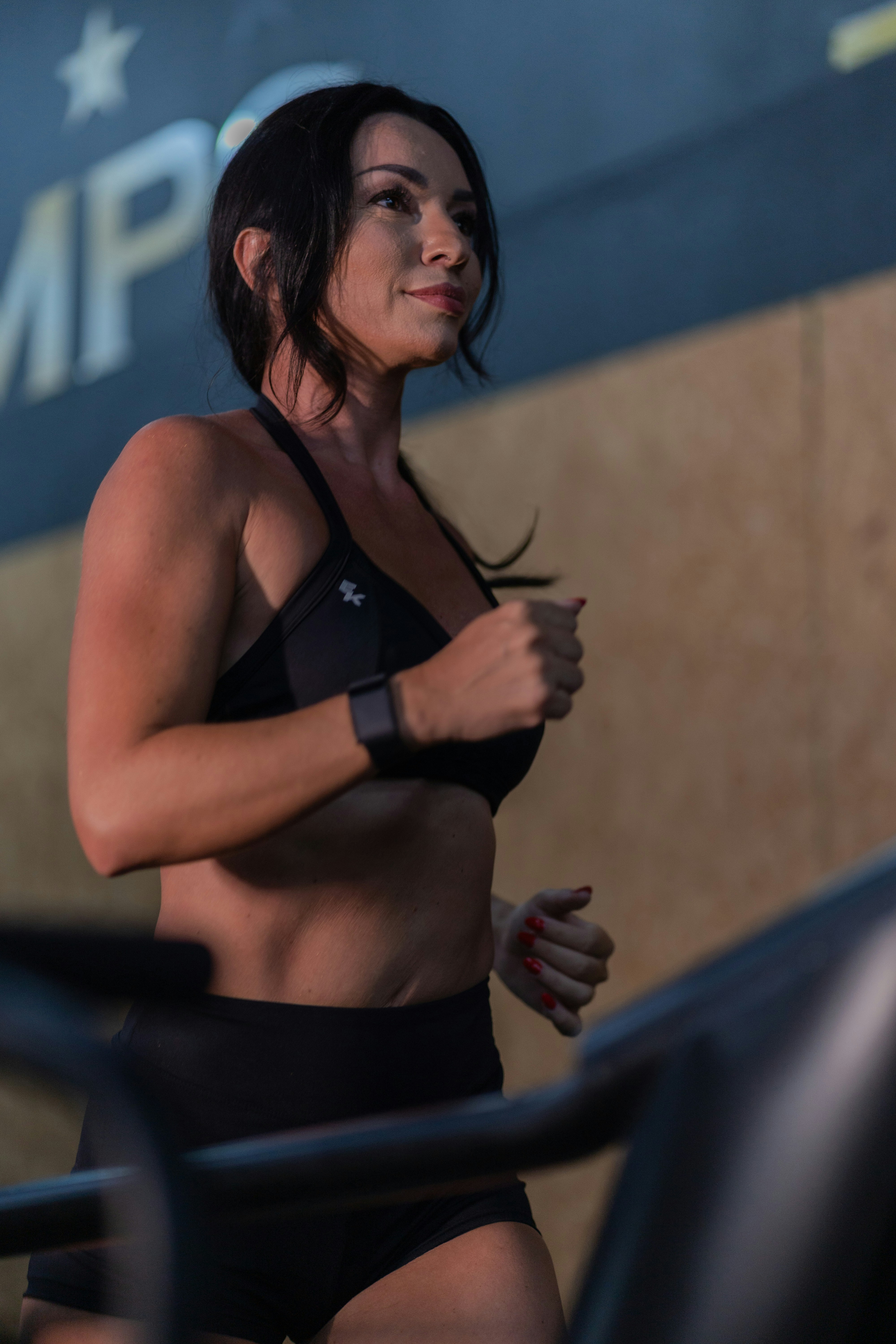 Woman running on a treadmill in a gym.
