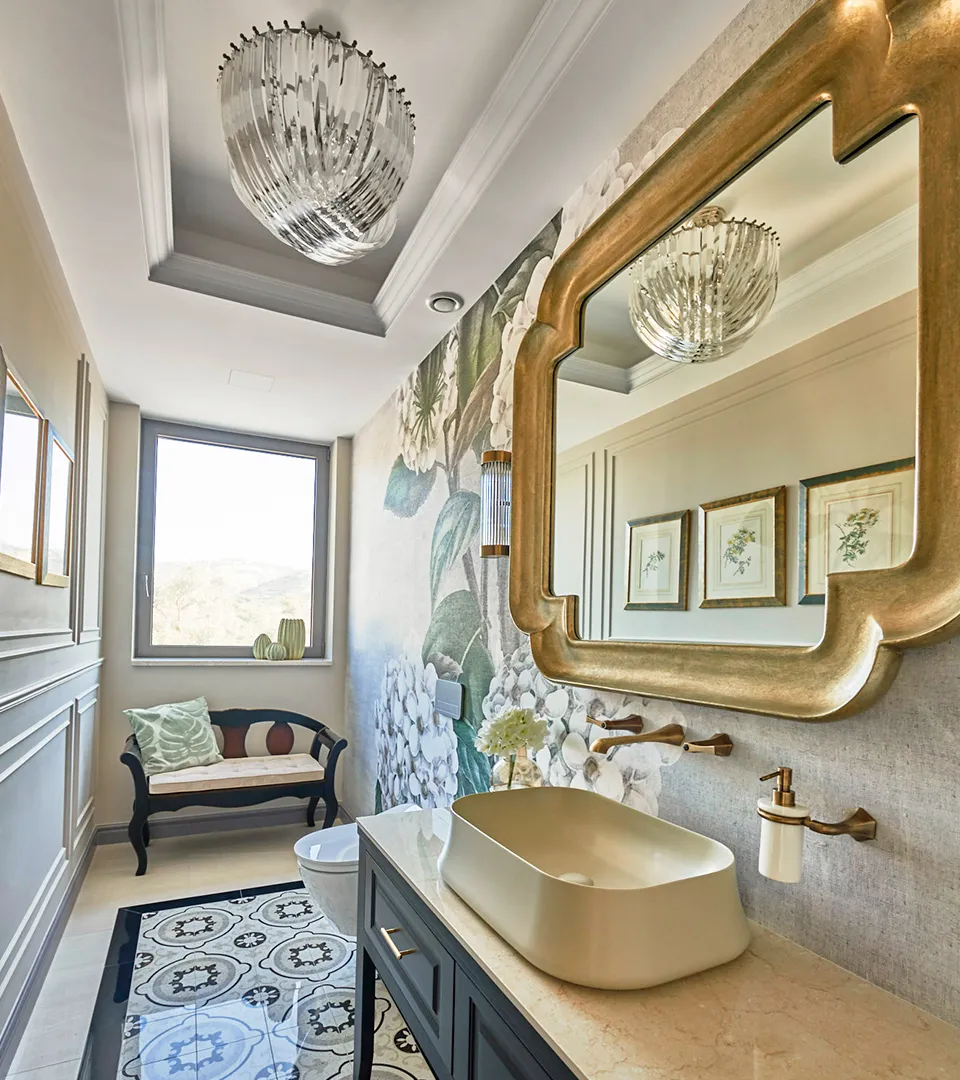 Villa Belmare powder room with floral wall mural, sculptural mirror, and modern basin vanity
