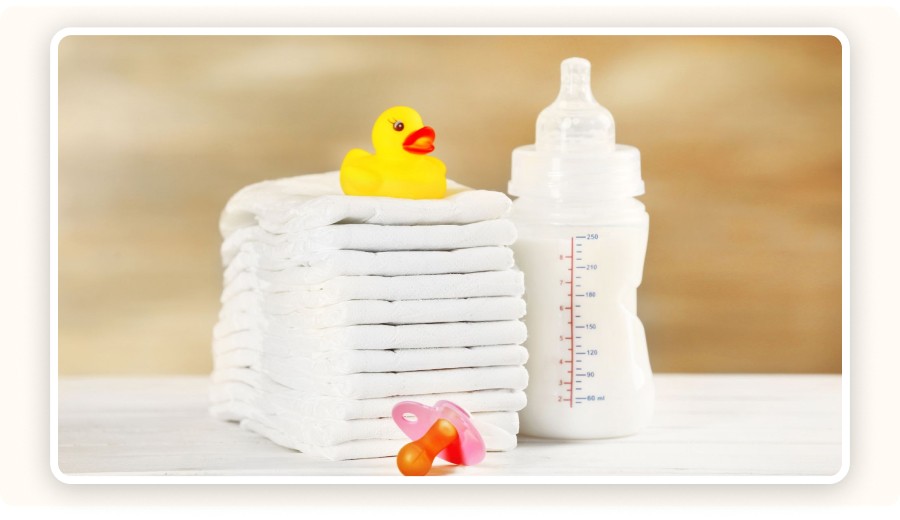 Baby diapers, milk-filled bottle, and pacifier