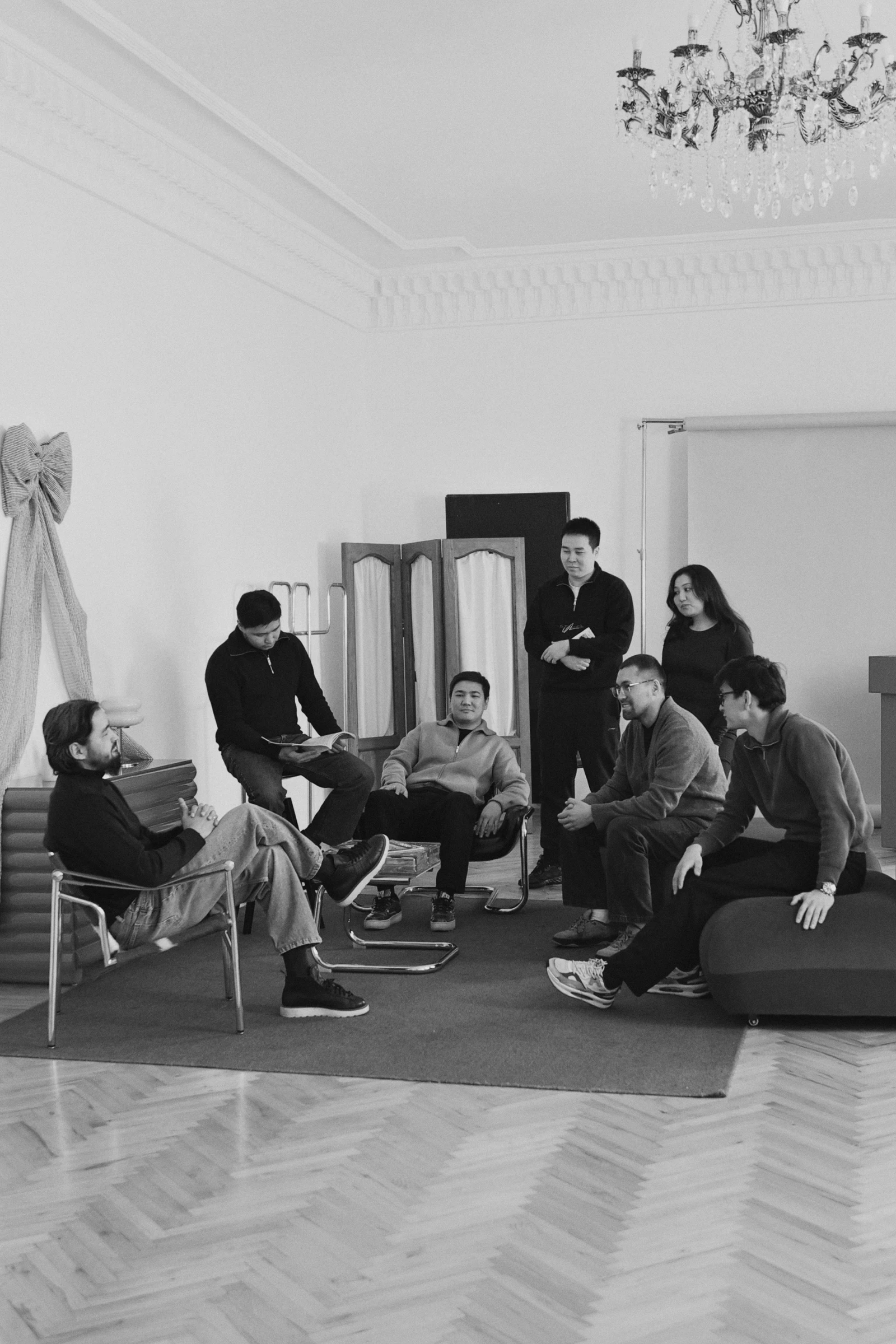 Two women sitting together in a cozy, well-lit workspace, smiling and collaborating over a laptop, with a coffee cup and a bowl on the table.