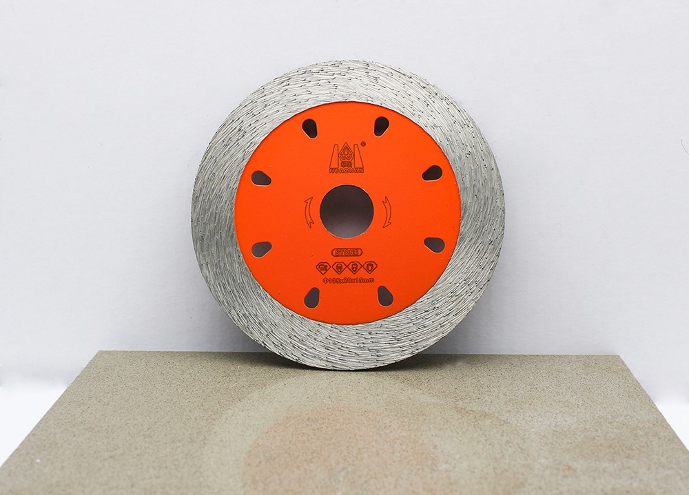 A single orange Sintered Continuous Turbo Blade placed on a stone surface.