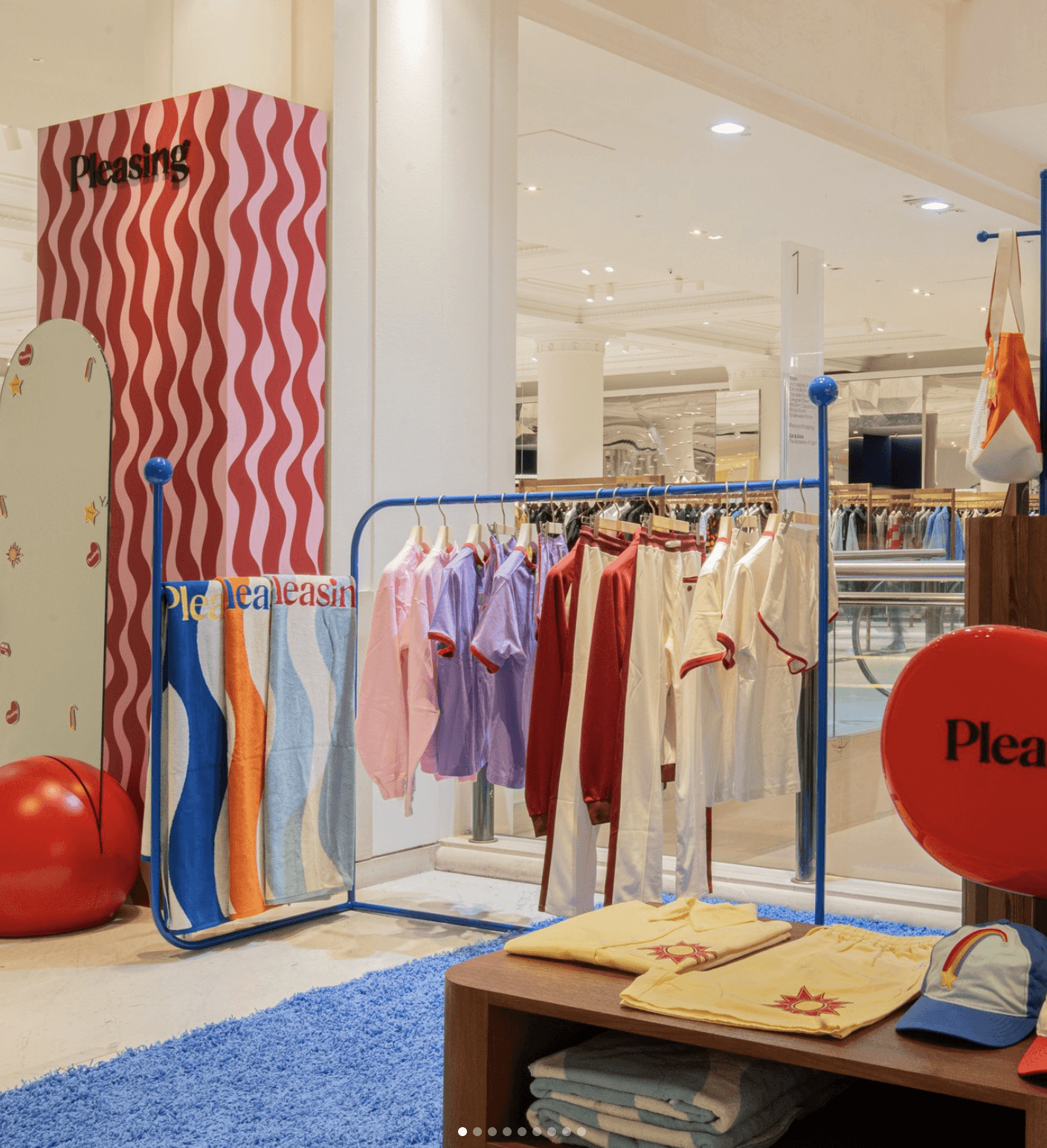 A colorful retail space featuring clothes on racks, vibrant decor, and a playful atmosphere.