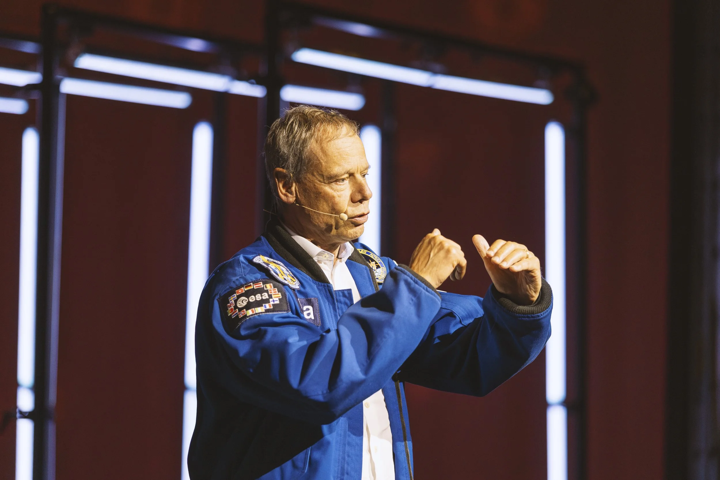 Presentatör i blå kavaj som talar i mikrofonen