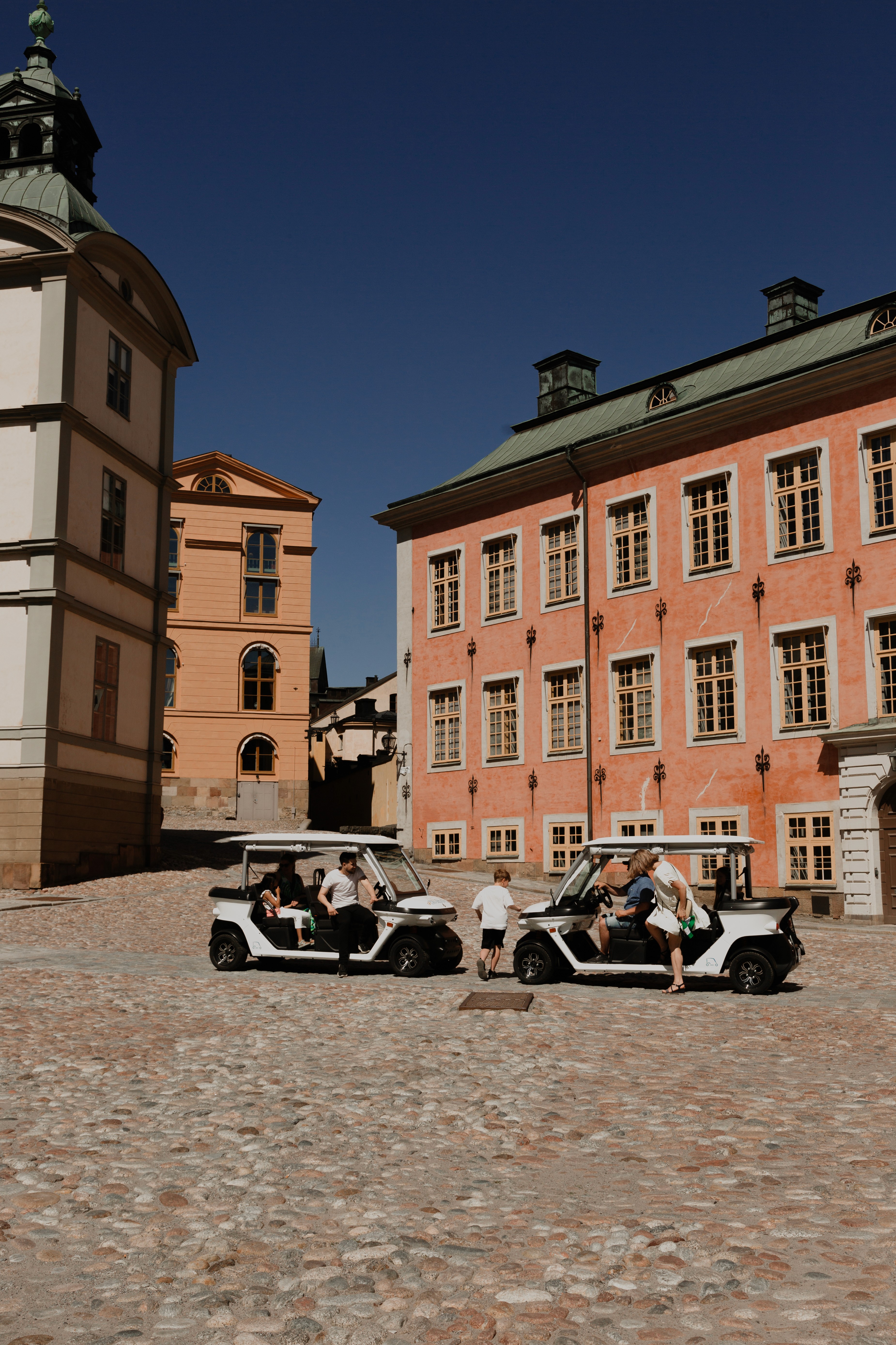Electric sightseeing carts in front of historic building in Stockholm