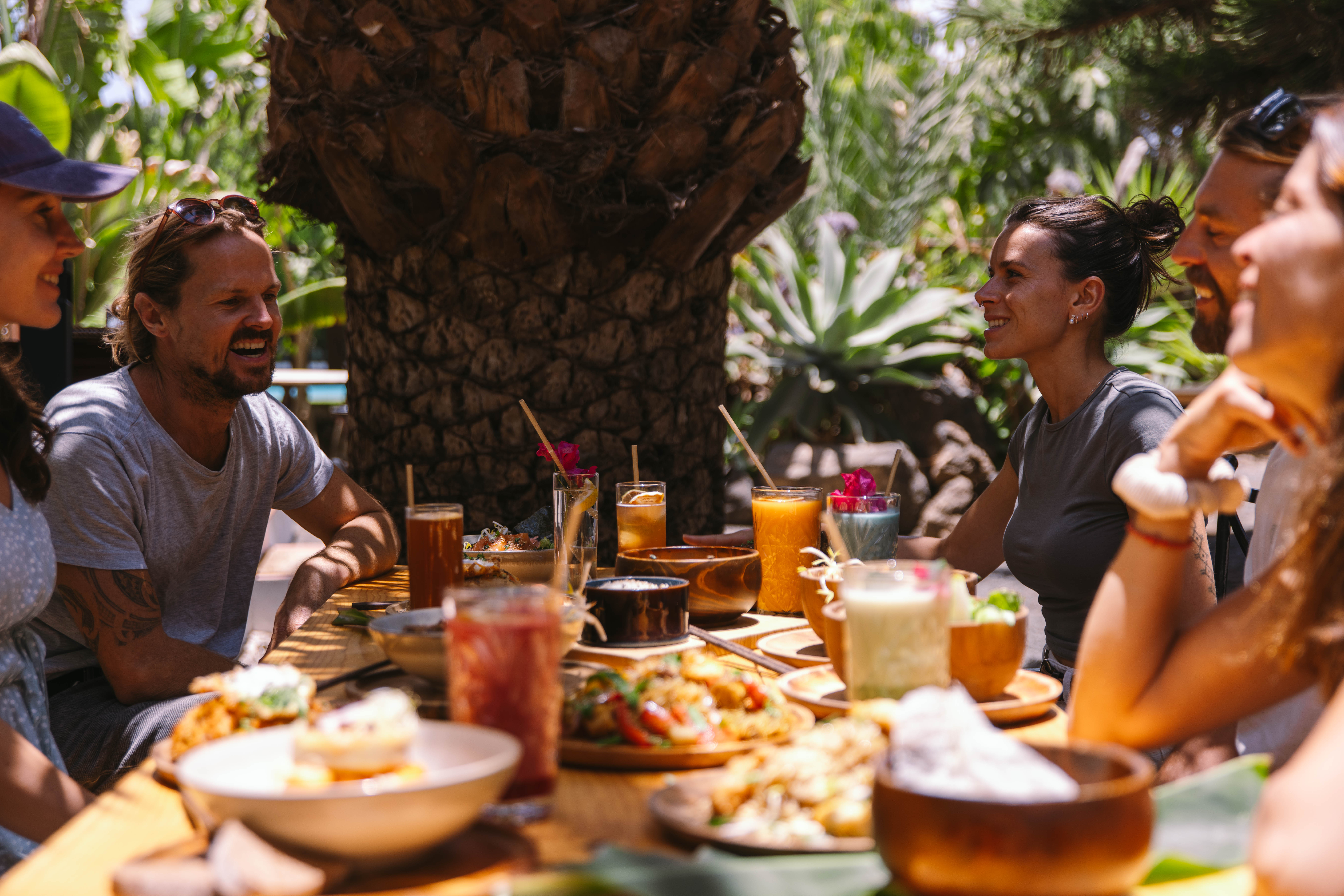 Friends laughing and dining together outdoors.