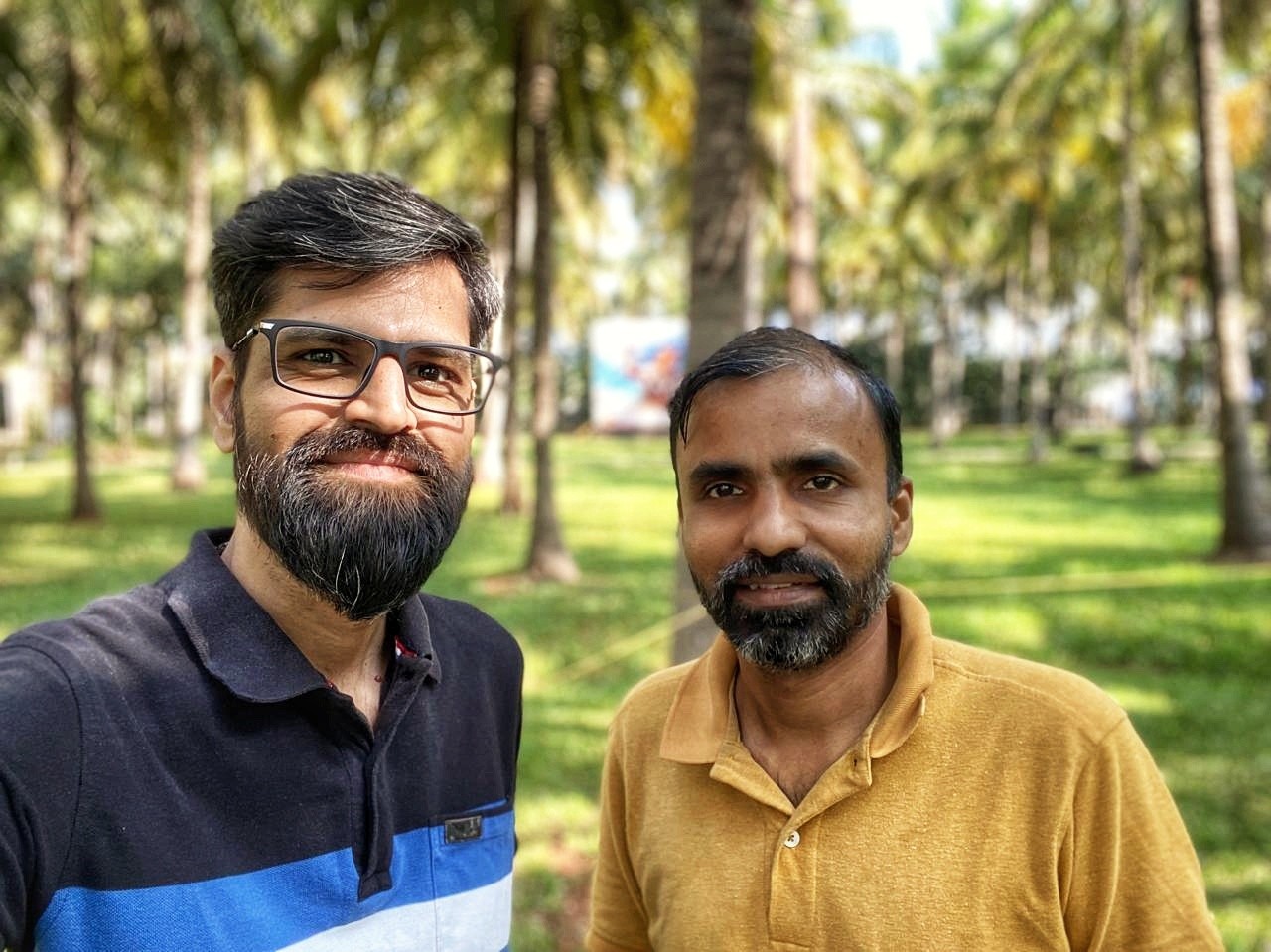 photo of two man and one woman standing near tree