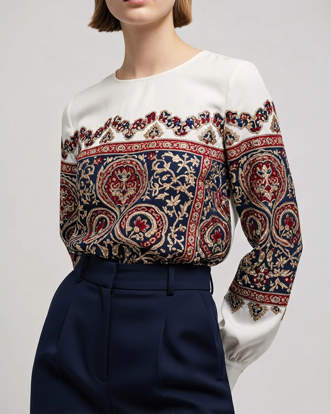 Elegant blouse with intricate patterns paired with tailored navy trousers, showcasing a sophisticated and stylish look.